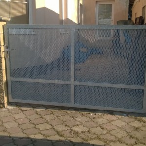 Jednoduchá kovová křídlová brána u vstupu do rodinného domu od firmy Konsorcium - KOVO